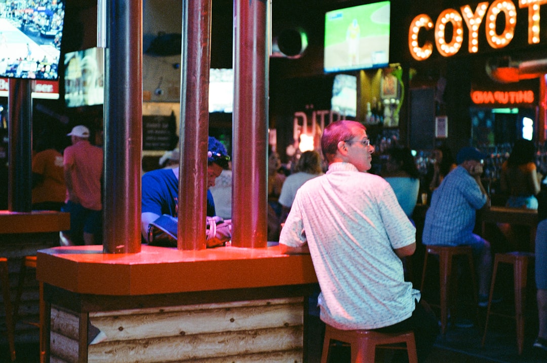 People sitting at a bar with screens in background