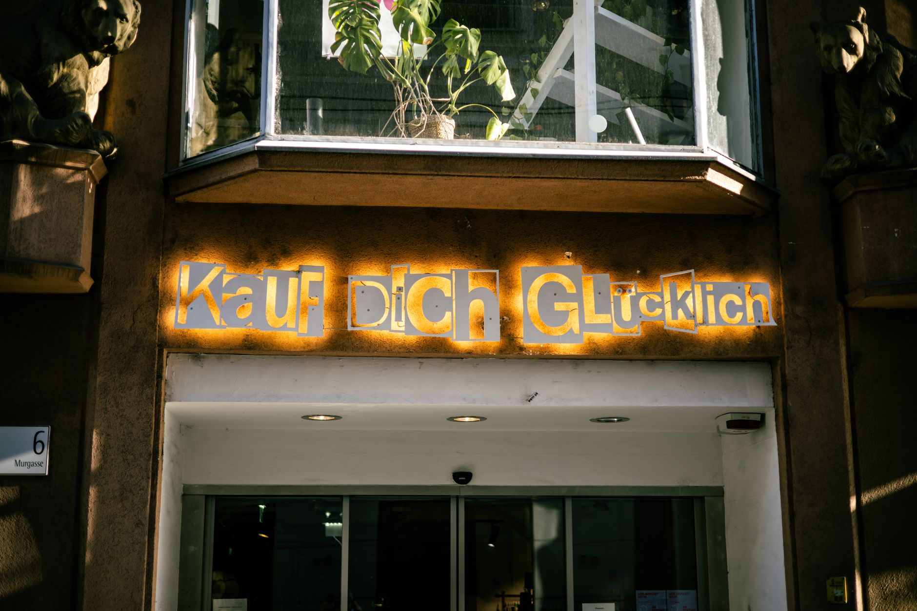 Street view of a shop entrance in Berlin with illuminated signage and urban facade details.