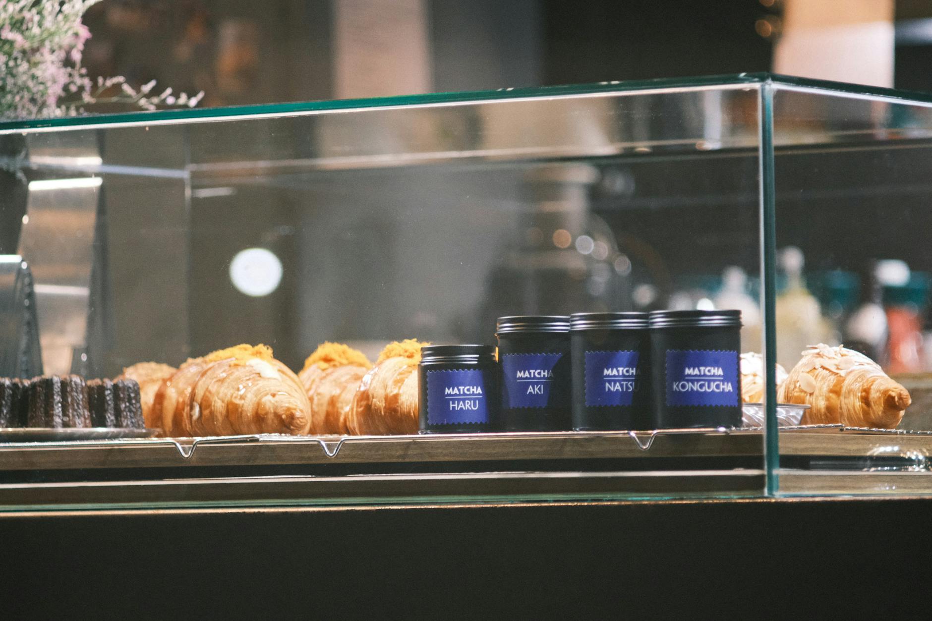 Delicious pastries and matcha tea neatly arranged in a sleek glass display case.