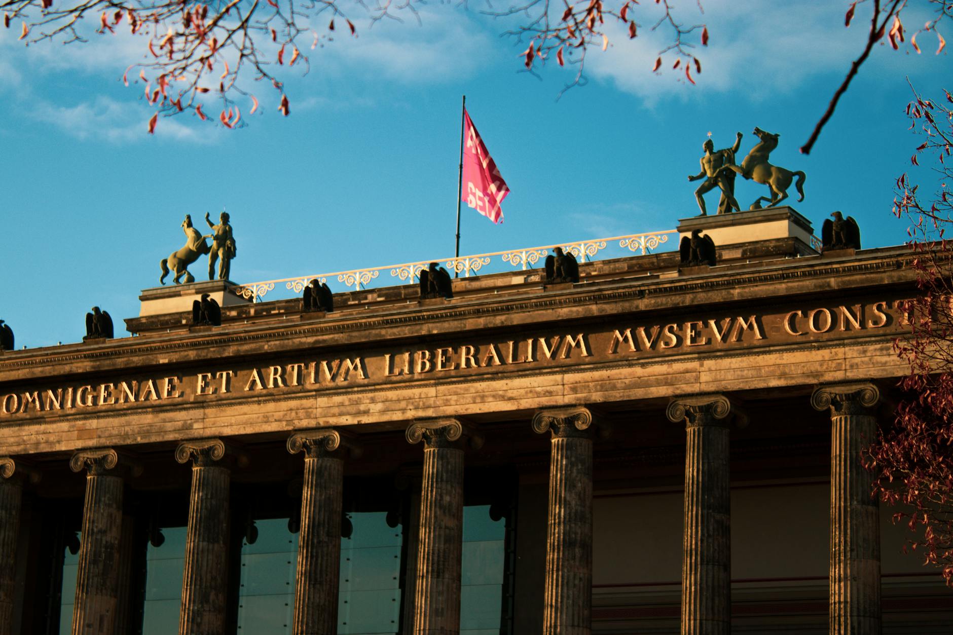 Elegant facade of Altes Museum in Berlin with sunlight illuminating classical architecture.