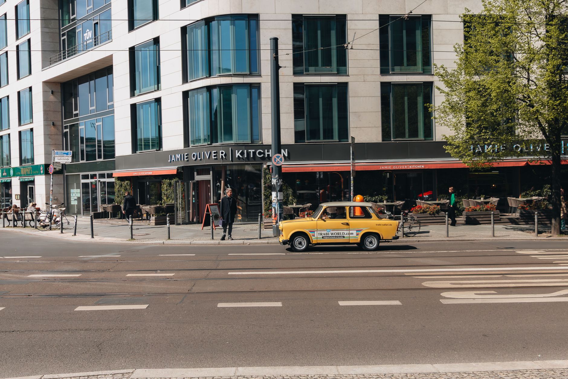 Yellow car in front of Jamie Oliver Kitchen on a sunny day in Berlin, Germany.