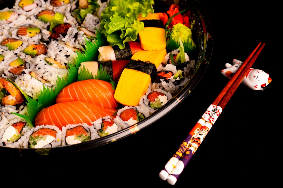 a plate of sushi with chopsticks next to it